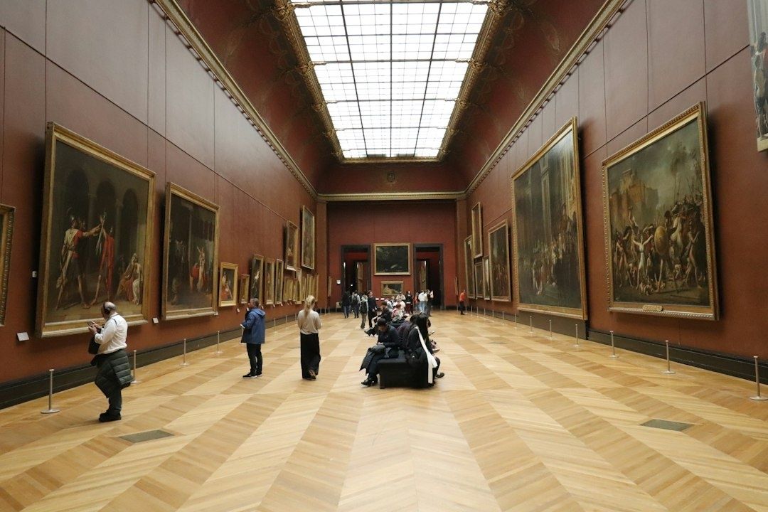 Ampia sala museale con dipinti storici e visitatori